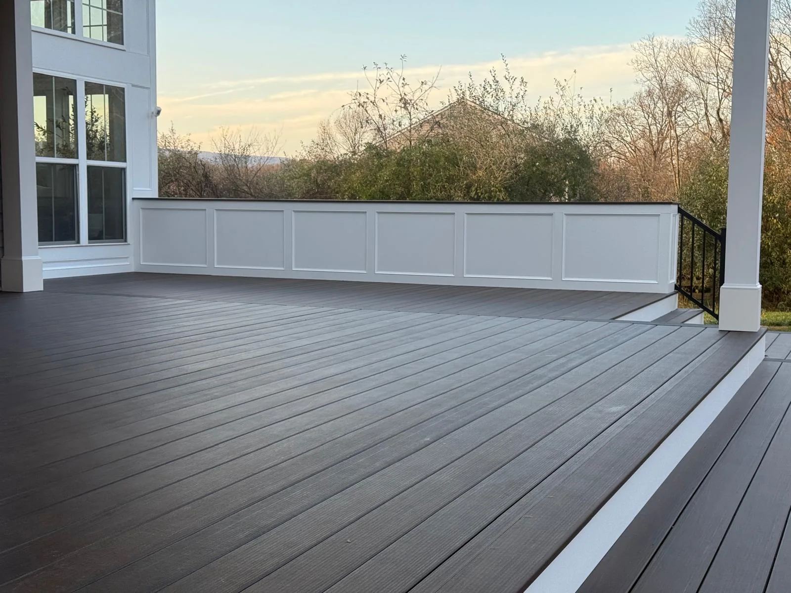 Woodgrain decking and border details beside white porch columns and a paneled privacy wall in Leesburg