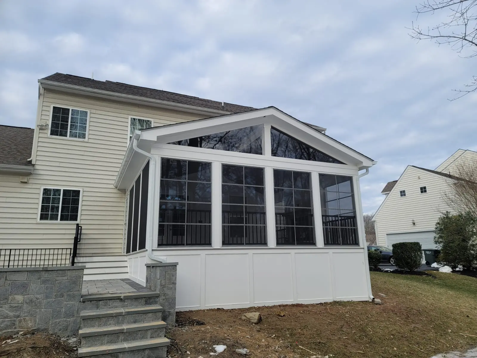 Custom screened porch addition with gable roof and large enclosure panels by BILDEN