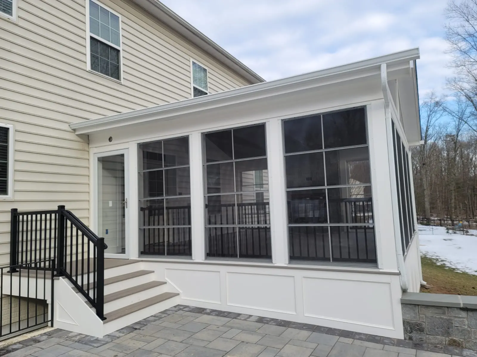 Finished screened porch addition connected to an existing patio and backyard